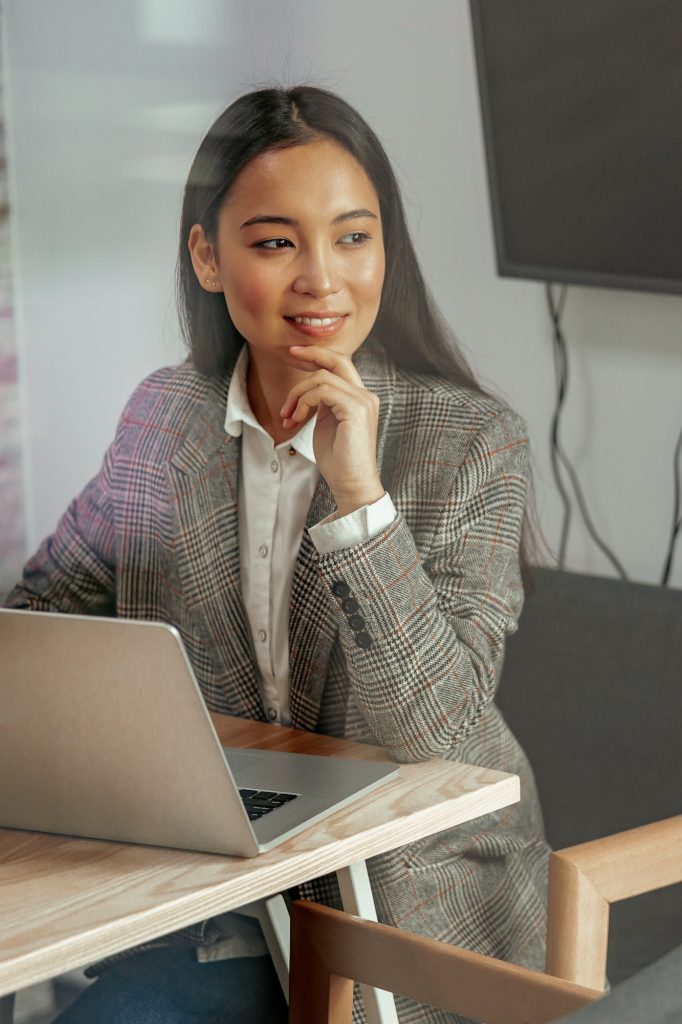 Portrait of smiling beautiful business asian woman working in office use computer